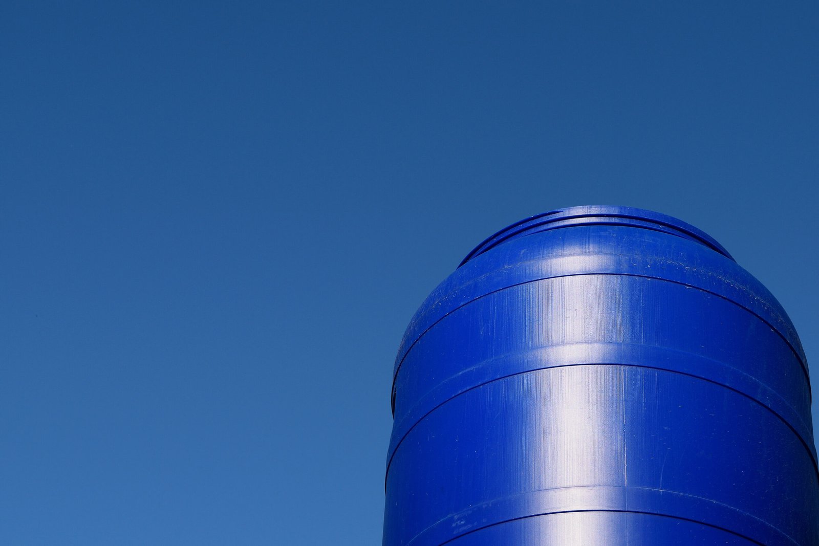 low-angle-view-smoke-stacks-against-clear-blue-sky
